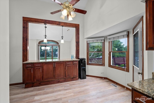 116 Pipers Dr, Bartlett, IL 60103 - kitchen featuring light wood-style flooring, stone countertops, lofted ceiling, ceiling fan, and decorative light fixtures
