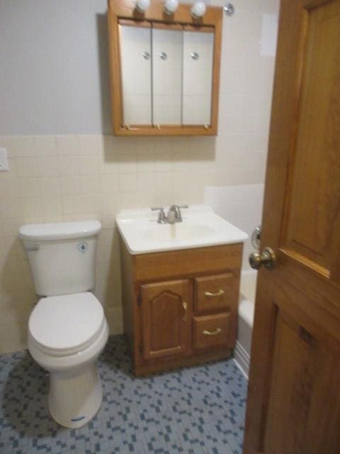 2012 W 111th St Unit 3S, Chicago, IL 60643 - bathroom with vanity, tile walls, a bath, and wainscoting
