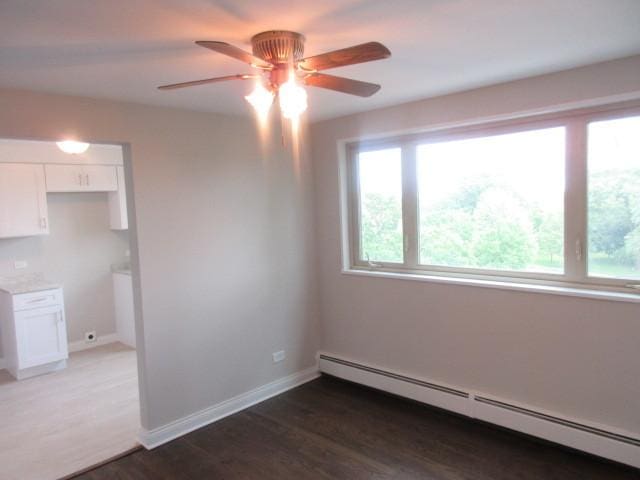 2012 W 111th St Unit 3S, Chicago, IL 60643 - unfurnished room featuring a baseboard radiator, ceiling fan, and wood finished floors