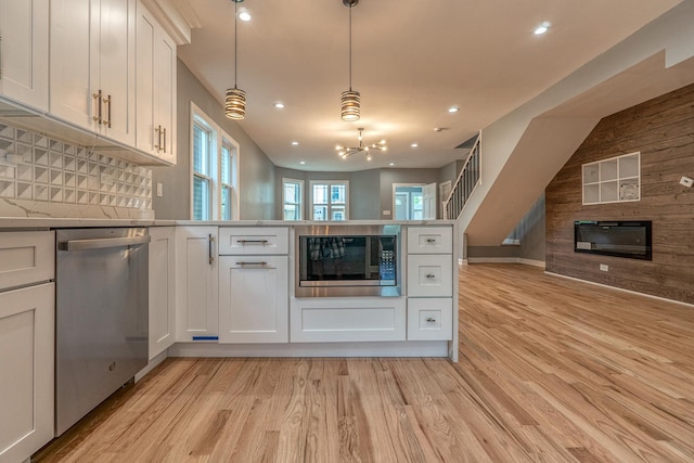 4826 W Potomac Ave, Chicago, IL 60651 - kitchen with stainless steel appliances, open floor plan, light wood finished floors, a peninsula, and recessed lighting