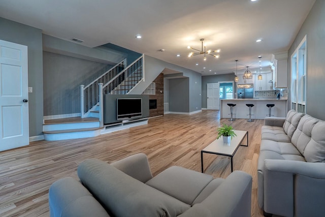 4826 W Potomac Ave, Chicago, IL 60651 - living room with a chandelier, light wood-type flooring, recessed lighting, stairway, and a fireplace