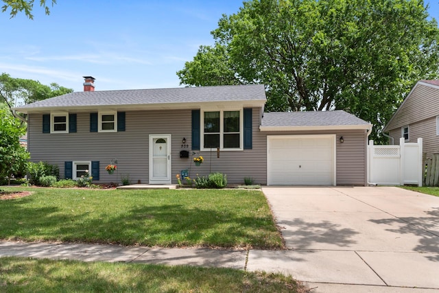 509 Waverly Ave, Streamwood, IL 60107 - split foyer home with a garage, driveway, a chimney, and a shingled roof