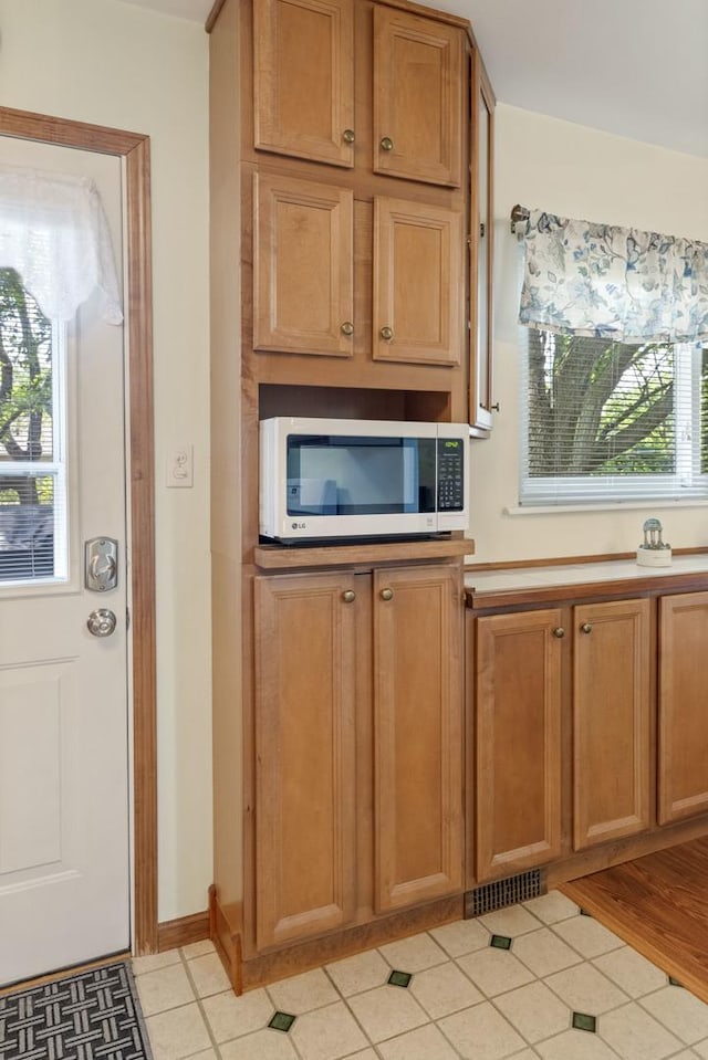 509 Waverly Ave, Streamwood, IL 60107 - kitchen featuring stainless steel microwave, plenty of natural light, light tile patterned floors, and light countertops