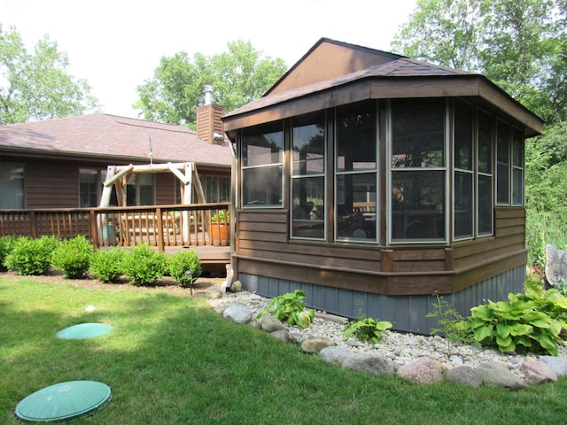 24099 W Haidi Ln, Lake Villa, IL 60046 - back of house featuring a sunroom, a wooden deck, a chimney, and a lawn