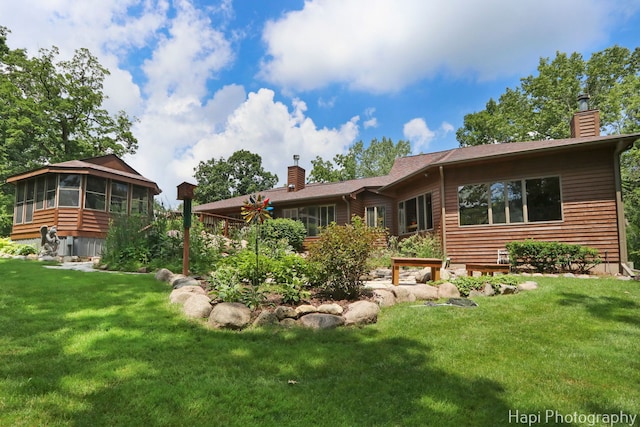 24099 W Haidi Ln, Lake Villa, IL 60046 - back of property with a chimney, a sunroom, and a lawn