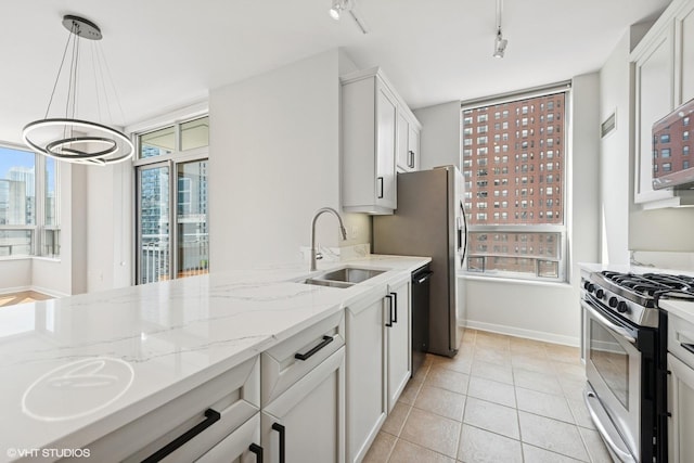 330 W Grand Ave Unit 1101, Chicago, IL 60654 - kitchen featuring stainless steel gas range oven, track lighting, light stone counters, a chandelier, and light tile patterned flooring