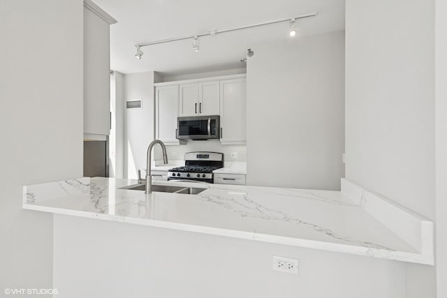 330 W Grand Ave Unit 1101, Chicago, IL 60654 - kitchen featuring stainless steel appliances, light stone counters, rail lighting, and a peninsula