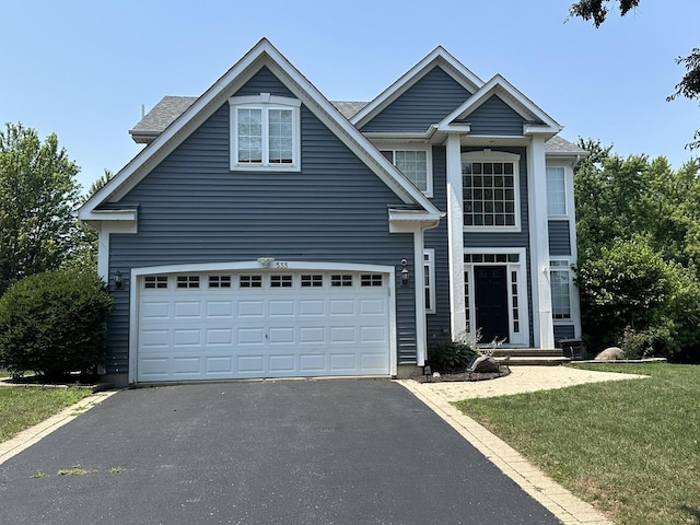 533 Jackson Blvd, Grayslake, IL 60030 - traditional-style house with asphalt driveway, a front lawn, and an attached garage