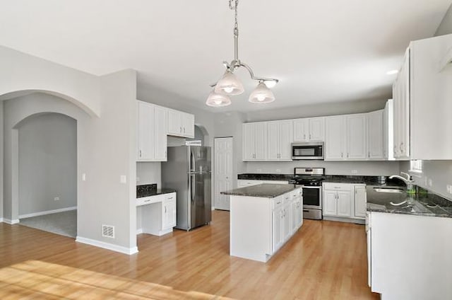 533 Jackson Blvd, Grayslake, IL 60030 - kitchen featuring appliances with stainless steel finishes, a center island, arched walkways, a chandelier, and light wood-style flooring