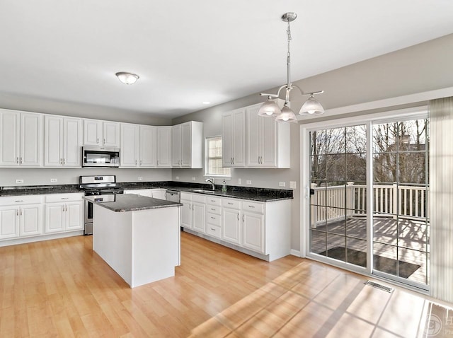 533 Jackson Blvd, Grayslake, IL 60030 - kitchen with stainless steel appliances, a chandelier, white cabinets, light wood finished floors, and a center island
