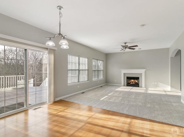 533 Jackson Blvd, Grayslake, IL 60030 - unfurnished living room featuring a ceiling fan, a fireplace with flush hearth, a chandelier, and wood finished floors