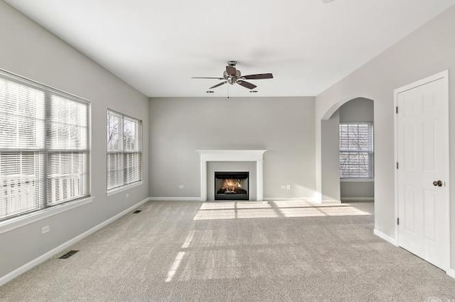 533 Jackson Blvd, Grayslake, IL 60030 - unfurnished living room with ceiling fan, carpet flooring, arched walkways, and a fireplace with flush hearth