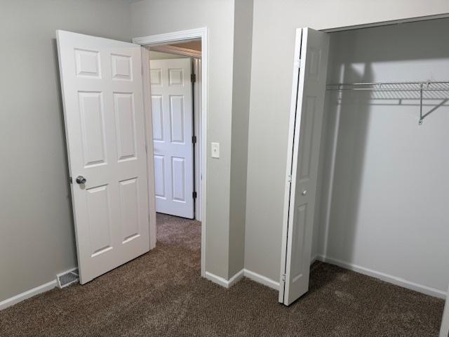 3018 20th St, North Chicago, IL 60064 - unfurnished bedroom with dark carpet and a closet
