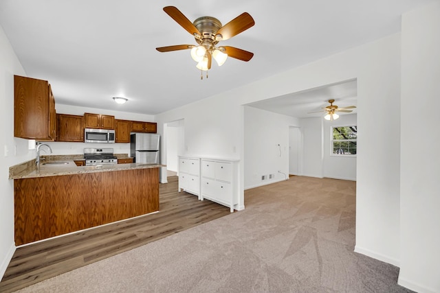 643 N Bridgeport Ter, Lindenhurst, IL 60046 - kitchen with appliances with stainless steel finishes, a peninsula, a ceiling fan, carpet, and brown cabinetry
