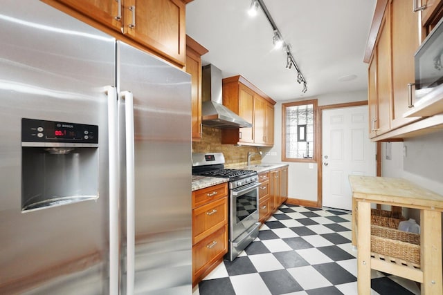 2753 N Spaulding Ave Unit Gs, Chicago, IL 60647 - kitchen featuring appliances with stainless steel finishes, wall chimney range hood, dark flooring, tasteful backsplash, and track lighting