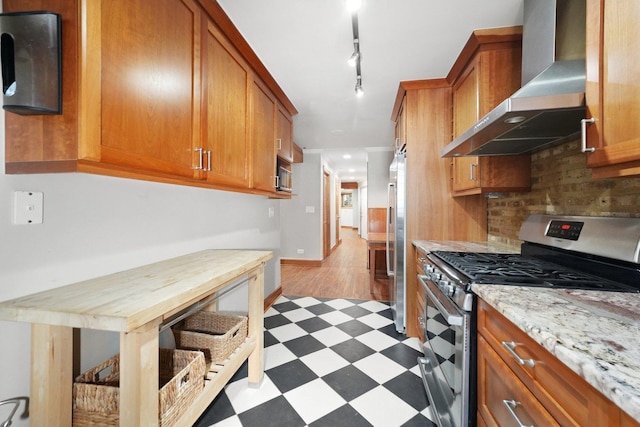 2753 N Spaulding Ave Unit Gs, Chicago, IL 60647 - kitchen featuring stainless steel appliances, wall chimney exhaust hood, light floors, brown cabinetry, and tasteful backsplash