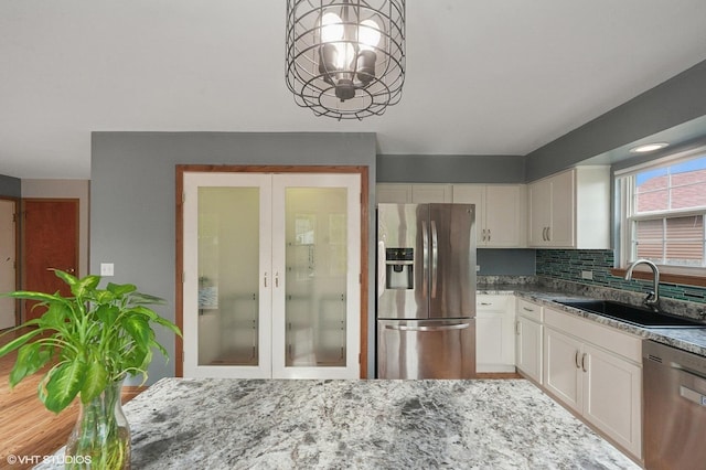 1531 Southport Ct, Zion, IL 60099 - kitchen with appliances with stainless steel finishes, white cabinetry, stone counters, and a chandelier