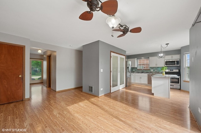 1531 Southport Ct, Zion, IL 60099 - unfurnished living room featuring ceiling fan, light wood finished floors, and plenty of natural light
