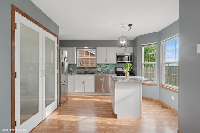 1531 Southport Ct, Zion, IL 60099 - kitchen featuring stainless steel appliances, tasteful backsplash, light wood finished floors, and white cabinetry