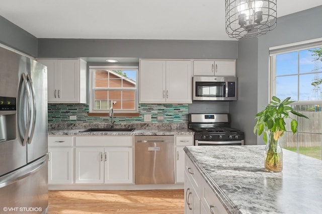 1531 Southport Ct, Zion, IL 60099 - kitchen featuring appliances with stainless steel finishes, white cabinetry, decorative backsplash, and light stone countertops