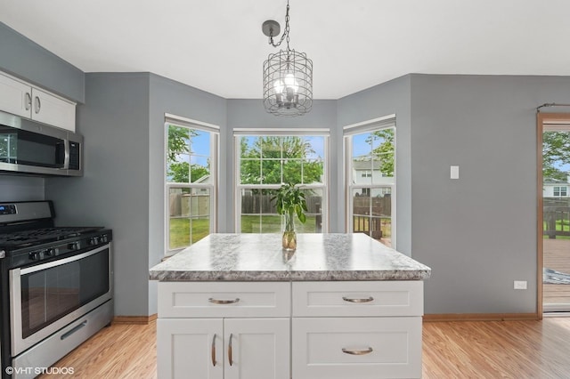 1531 Southport Ct, Zion, IL 60099 - kitchen with appliances with stainless steel finishes, light wood-type flooring, white cabinets, and healthy amount of natural light