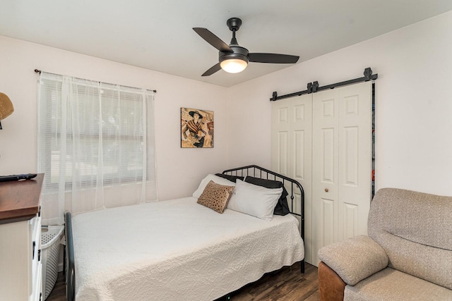 2308 Maple Ln, Rolling Meadows, IL 60008 - bedroom featuring a barn door, dark wood-style flooring, ceiling fan, and a closet