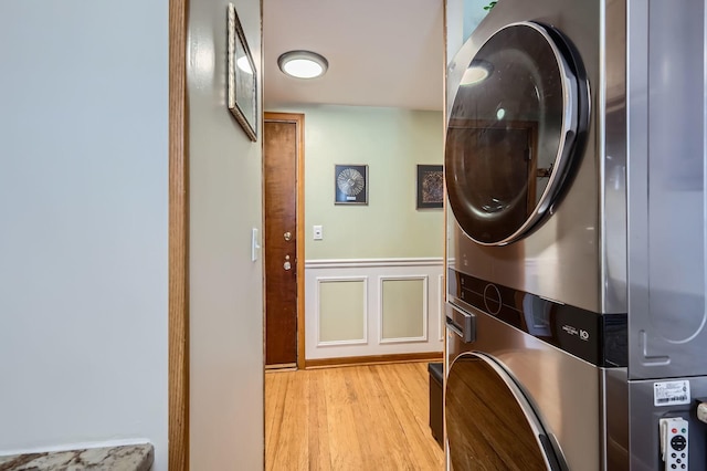 28 S 6th Ave Unit 1D, La Grange, IL 60525 - laundry room with stacked washing machine and dryer, light wood-style floors, and a wainscoted wall