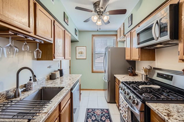 28 S 6th Ave Unit 1D, La Grange, IL 60525 - kitchen featuring stainless steel appliances, ceiling fan, light stone counters, light tile patterned flooring, and brown cabinetry