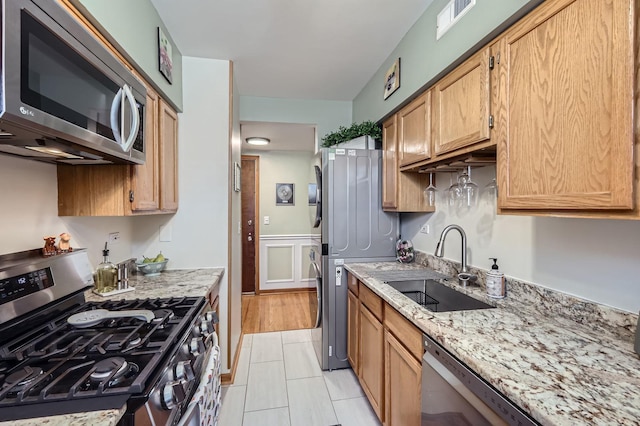 28 S 6th Ave Unit 1D, La Grange, IL 60525 - kitchen featuring stainless steel appliances, light stone countertops, and a wainscoted wall
