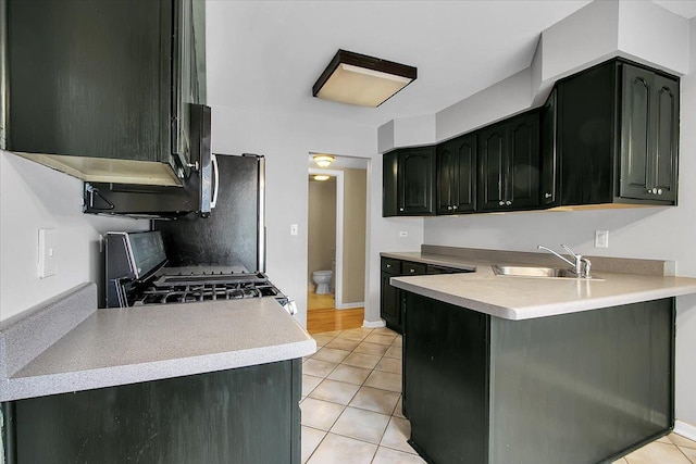 1921 Wisteria Ct Unit 3, Naperville, IL 60565 - kitchen with gas range, light tile patterned floors, light countertops, a peninsula, and dark cabinets