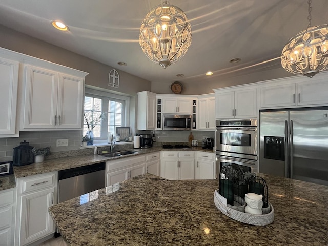 12534 Lily Ln, Plainfield, IL 60585 - kitchen featuring stainless steel appliances, a chandelier, white cabinets, decorative backsplash, and recessed lighting