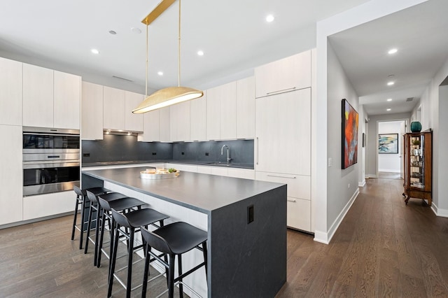 360 W Erie St Unit 3A, Chicago, IL 60654 - kitchen featuring modern cabinets, stainless steel double oven, dark wood-style flooring, a center island, and tasteful backsplash