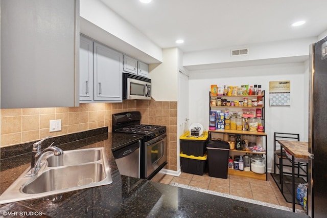 7200 N Ridge Blvd Unit 2C, Chicago, IL 60645 - kitchen with appliances with stainless steel finishes, light tile patterned floors, tasteful backsplash, recessed lighting, and dark stone counters