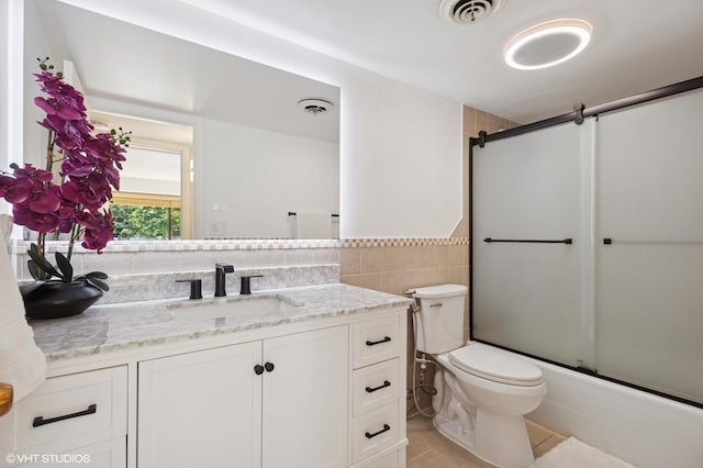 7200 N Ridge Blvd Unit 2C, Chicago, IL 60645 - full bath featuring vanity, tile patterned flooring, tile walls, bath / shower combo with glass door, and a wainscoted wall