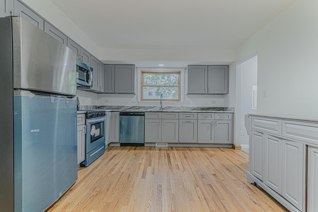 922 E Pratt Dr, Palatine, IL 60074 - kitchen with stainless steel appliances, gray cabinetry, light wood-style flooring, and light stone countertops