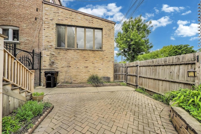 3215 S Calumet Ave, Chicago, IL 60616 - view of side of home with a patio, brick siding, and a fenced backyard