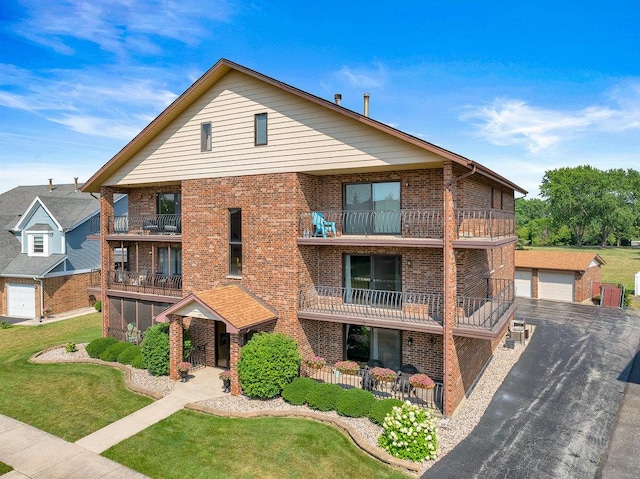 16719 Paxton Ave Unit 2S, Tinley Park, IL 60477 - view of front facade featuring a balcony, brick siding, an outbuilding, a front lawn, and a garage