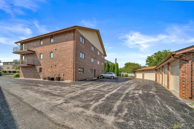 16719 Paxton Ave Unit 2S, Tinley Park, IL 60477 - view of home's exterior featuring community garages, a balcony, and brick siding