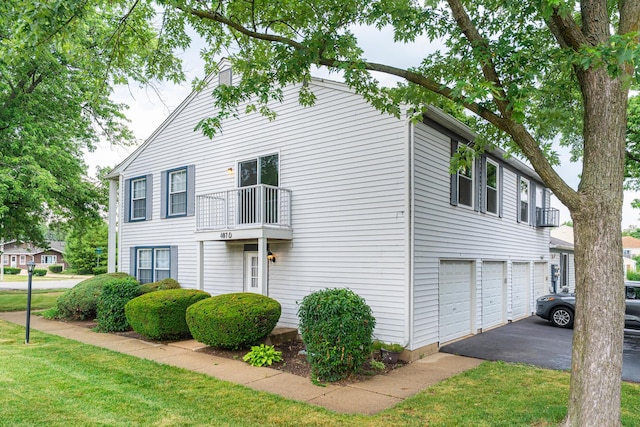 407 James Ct Unit D, Glendale Heights, IL 60139 - view of home's exterior with an attached garage, driveway, a balcony, and a lawn