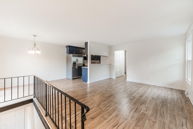 407 James Ct Unit D, Glendale Heights, IL 60139 - unfurnished living room featuring light wood-type flooring and a chandelier