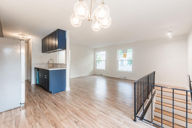 407 James Ct Unit D, Glendale Heights, IL 60139 - kitchen with freestanding refrigerator, light countertops, light wood-style flooring, a chandelier, and open floor plan
