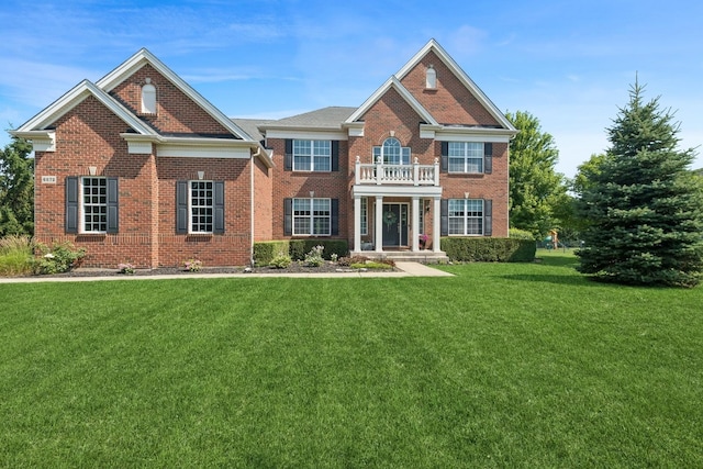 6072 Westminster Ln, Gurnee, IL 60031 - colonial home featuring a balcony, a front lawn, and brick siding
