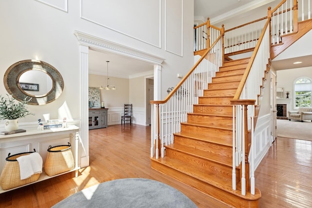 6072 Westminster Ln, Gurnee, IL 60031 - stairway with ornamental molding, wood finished floors, a decorative wall, a towering ceiling, and wainscoting