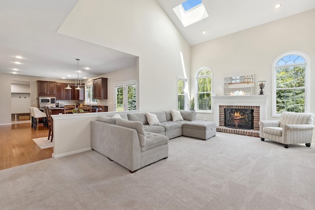 6072 Westminster Ln, Gurnee, IL 60031 - living room featuring plenty of natural light, a brick fireplace, a skylight, light colored carpet, and recessed lighting