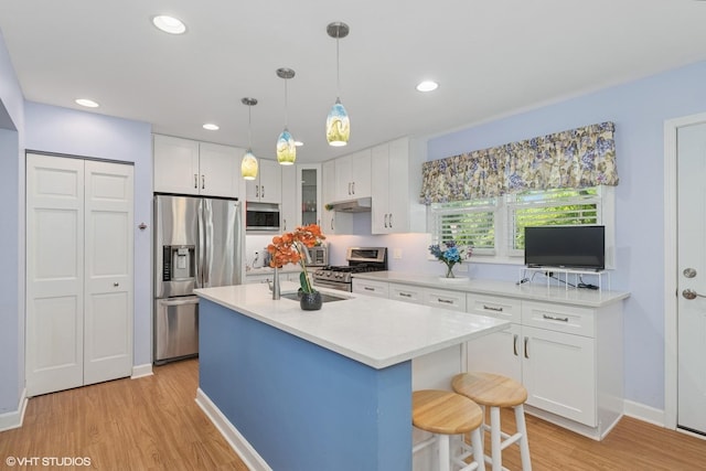 3513 Woodland Cir, Island Lake, IL 60042 - kitchen featuring stainless steel appliances, light countertops, light wood-type flooring, white cabinetry, and under cabinet range hood