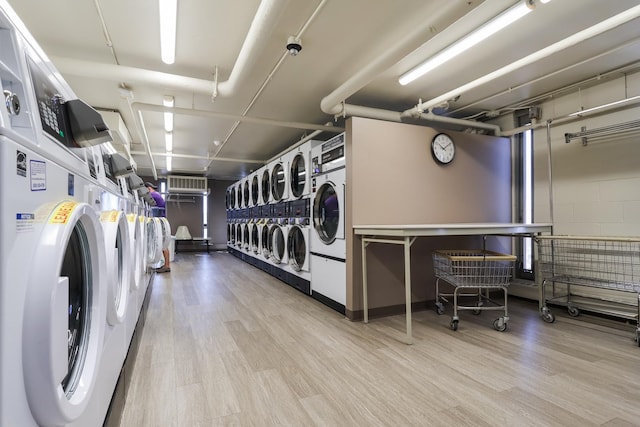 3550 N Lake Shore Dr Unit 2616, Chicago, IL 60657 - communal laundry room with estacked washer and dryer, washer and clothes dryer, wood finished floors, and an AC wall unit