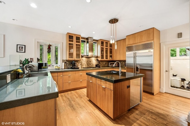 311 3rd St, Wilmette, IL 60091 - kitchen with stainless steel appliances, backsplash, light wood-style flooring, an island with sink, and recessed lighting