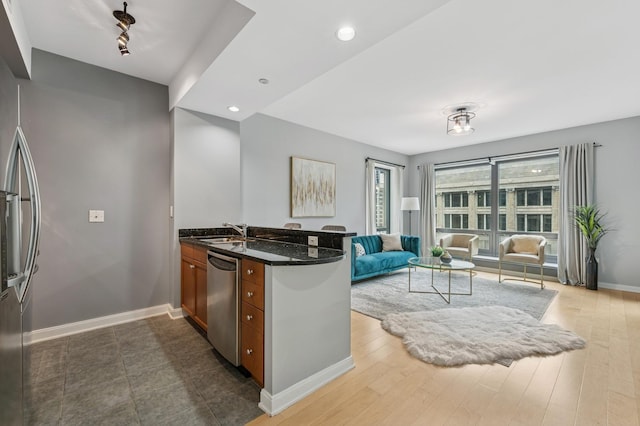 130 N Garland Ct Unit 1608, Chicago, IL 60602 - kitchen featuring appliances with stainless steel finishes, open floor plan, a peninsula, brown cabinets, and dark stone counters