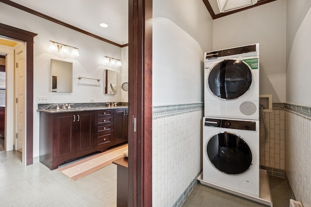 611 Lake Ave, Wilmette, IL 60091 - laundry area with stacked washer and clothes dryer, crown molding, tile walls, and a wainscoted wall