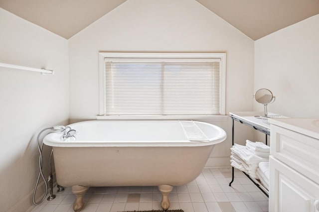 611 Lake Ave, Wilmette, IL 60091 - bathroom featuring vaulted ceiling, a freestanding bath, tile patterned floors, and vanity